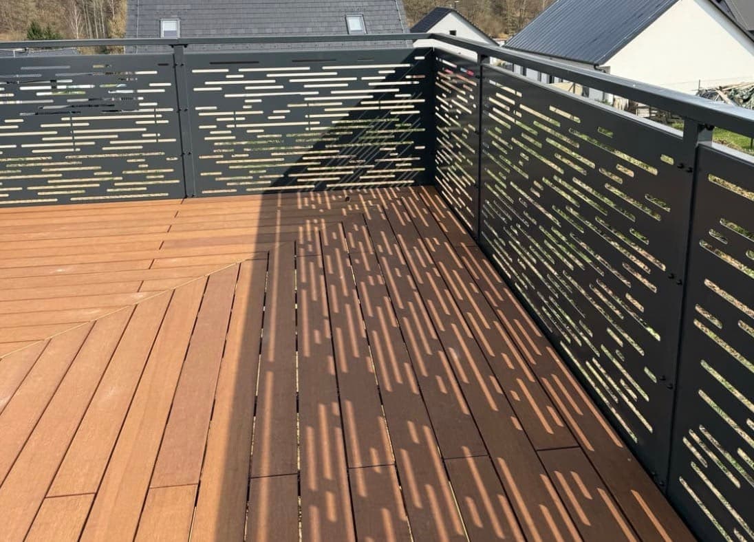 Moderní ocelové zábradlí s CNC vzorem | KOVOSET Designové kovové zábradlí s laserem vyřezávaným vzorem na terase s dřevěnou podlahou.