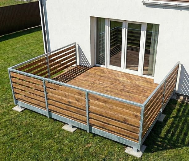 Ocelová terasa s dřevěnou podlahou a zábradlím | KOVOSET Moderní ocelová terasa KOVOSET s dřevěnou výplní zábradlí a podlahou u rodinného domu.