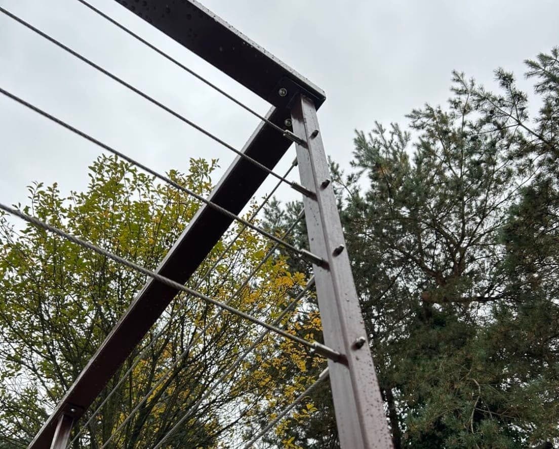 Ocelové zábradlí s lankovou výplní | KOVOSET Detail ocelové konstrukce zábradlí s nerezovými lanky pro moderní venkovní terasu.